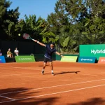 Player enjoying tennis on Hybrid Clay court with natural clay texture and vibrant surroundings.